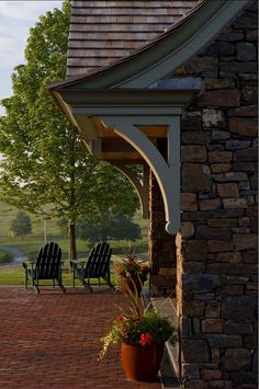 a brick patio with two chairs and a potted plant on the side of it