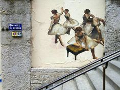 a painting on the side of a building with three women in white dresses and one is dancing