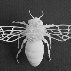 a paper sculpture of a bee on a black background