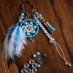 a blue and white dream catcher keychain sitting on top of a wooden table