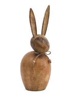 a wooden sculpture of a rabbit sitting on top of an apple with its head turned to the side