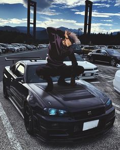 a person jumping on top of a car in a parking lot