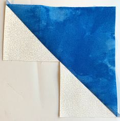 two pieces of blue and white fabric sitting next to each other on top of a table