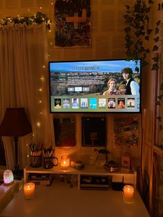 a flat screen tv sitting on top of a white table in a living room next to a window