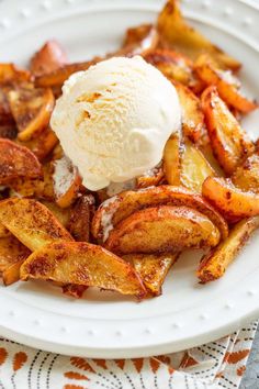 a white plate topped with french fries and an ice cream scooping on top of it