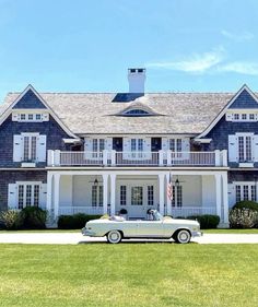 an old car parked in front of a large house