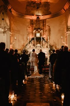 a bride and groom standing at the end of their wedding ceremony with candles in front of them