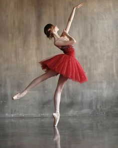 a young ballerina in a red tutu and leotard