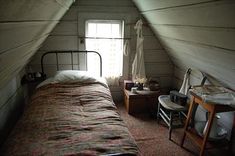 an attic bedroom with a bed and desk in it