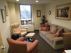 a living room with couches, chairs and a coffee table in front of a window