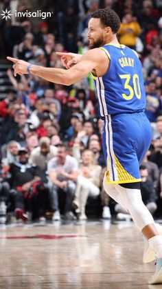 a basketball player in blue and yellow is on the court with his hand out to someone