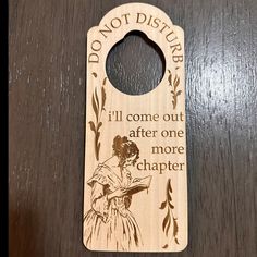 a wooden door hanger with an image of a woman reading