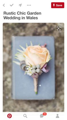 a boutonniere with an orange rose and other flowers on top of it