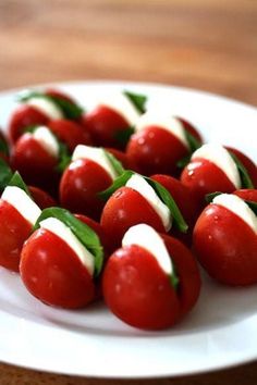 small red and white candies on a plate with green leafy garnish