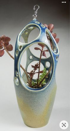 a blue and white vase with some plants in it