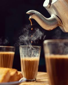 coffee being poured into a glass on top of a table