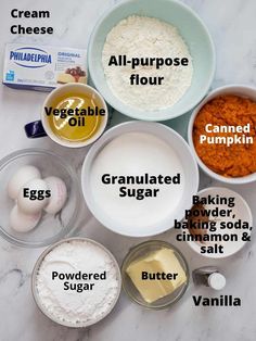 ingredients for pumpkin pie laid out on a marble counter top, including eggs, flour, butter, and other ingredients