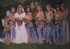 a group of women standing next to each other on top of a lush green field