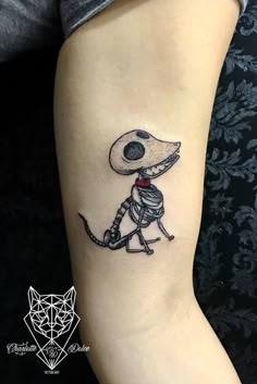 a small tattoo on the leg of a person with a skeleton in it's head