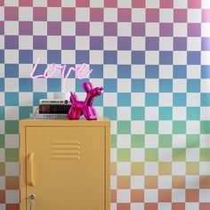 a yellow locker sitting next to a wall with a love sign on top of it