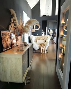 a living room filled with lots of furniture and decor on top of hard wood flooring