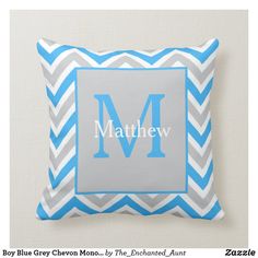 a gray and blue chevron pillow with the letter m on it