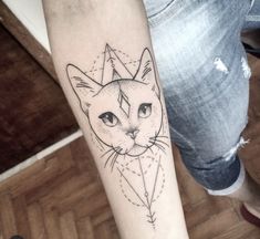 a black and white cat tattoo on the left inner arm, with an arrow in the middle