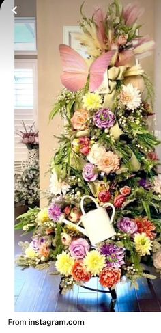 an arrangement of flowers is displayed on a table with a coffee cup in the center