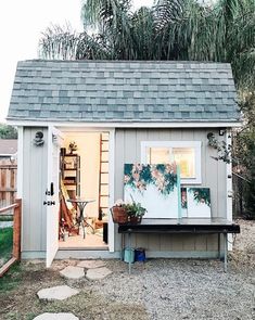 a small shed with a ladder to the door and potted plants on the outside