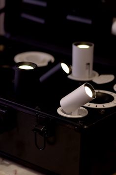 a black suitcase with some white plates and lights on it's lid, in front of other items