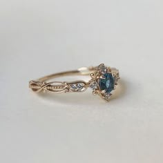 a gold ring with blue and white stones on it, sitting on top of a table