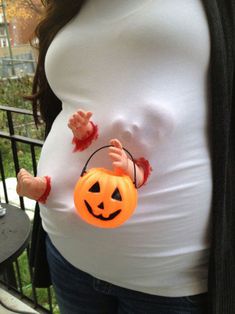 a pregnant woman holding a trick or treat in her hand with the caption never too young for trick or treating