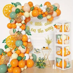 an orange themed birthday party with balloons and garlands on the wall, citrus theme