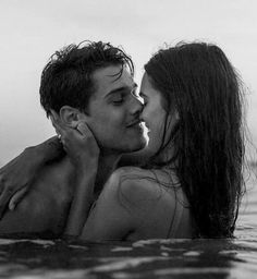 a man and woman are kissing in the water