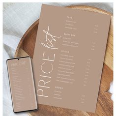 the price list is displayed next to a phone on a wooden tray with white linen