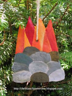 an ornament hanging from a tree decorated with rocks