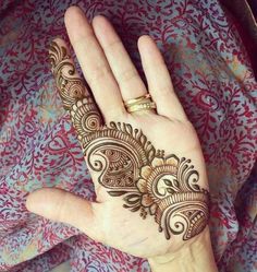 a woman's hand with henna tattoos on it