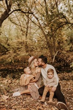 a man and woman sitting on the ground with their two children