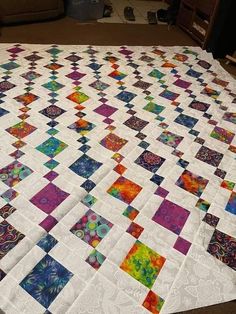 a colorful quilt is laying on the floor