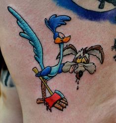 a cartoon character tattoo on the side of a woman's stomach, with birds flying around