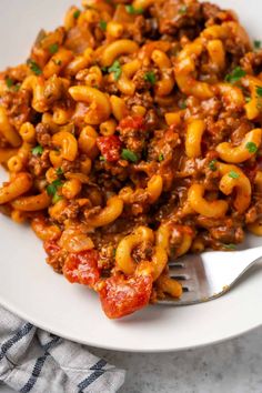 a white plate topped with pasta and meat