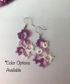 crochet earrings with pink and white beads on them, sitting on a table