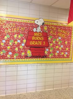 a bulletin board in the middle of a subway station with snoopy characters on it