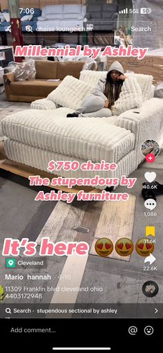 a woman laying on top of a white couch next to a pile of boxes and furniture