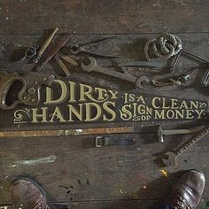 dirty hands sign on wooden floor with shoes and hammers next to it that says dirty hands