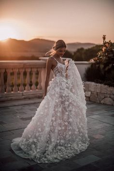 a woman in a wedding dress is taking a selfie with her cell phone while standing outside