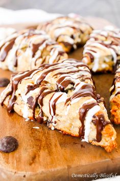 a chocolate covered pastry on a wooden cutting board with one slice cut out and the other half eaten