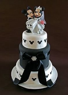 a wedding cake with mickey and minnie mouse figurines on top