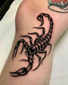 a black scorpion tattoo on the arm