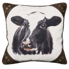 a black and white cow with brown spots on it's face is shown in this decorative pillow